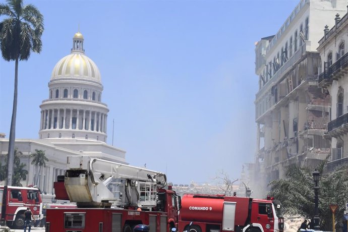 Camiones de bomberos junto al Hotel Saratoga de La Habana con la cúpula del Capitolio de la capital cubana al fondo