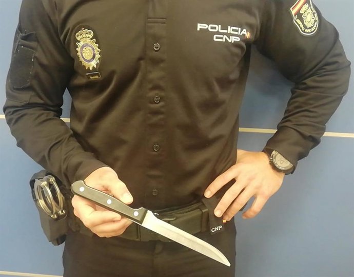 Un agente sostiene el cuchillo con el que el detenido amenazó al vigilante de seguridad.
