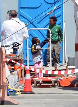 Archivo - Personal de Salvamar Alpheratz atiende dos niños migrantes procedentes de una patera en el Puerto de los Cristianos, en Tenerife.