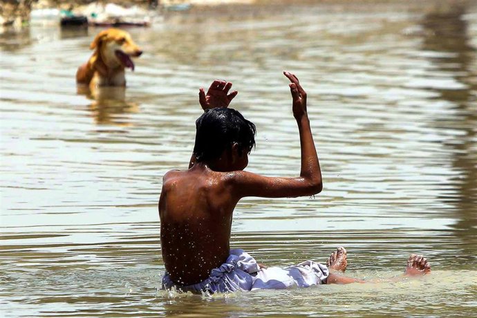 Archivo - 16 June 2020, Pakistan, Malir: A boy takes a bath at a roadside water pond to beat the heat of the sun. Photo: -/PPI via ZUMA Wire/dpa