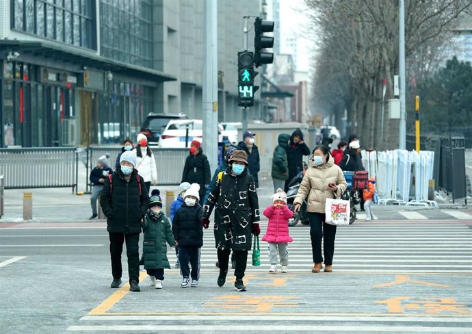 Archivo - 18 February 2022, China, Beijing: Families cross a street. Photo: Andrew Milligan/PA Wire/dpa