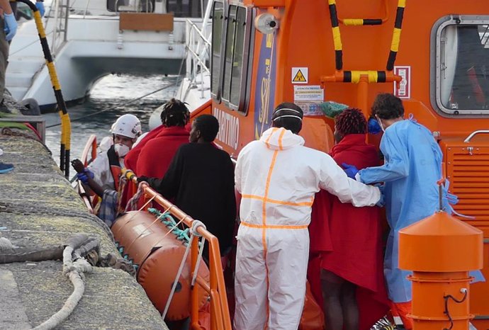 Archivo - Agentes de salvamento marítimo ayudan a un hombre migrante a desembarcar en Arguineguín (Gran Canaria)
