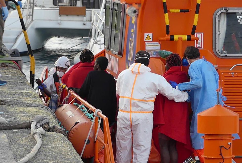 Archivo - Agentes de salvamento marítimo ayudan a un hombre migrante a desembarcar en Arguineguín (Gran Canaria)