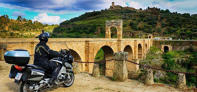 Un mototurista en el puente romano de Alcántara (Cáceres)