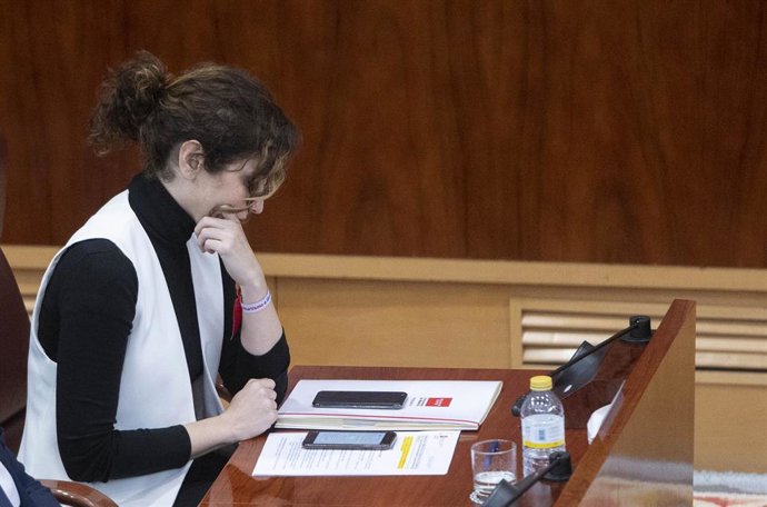 Archivo - La presidenta de la Comunidad de Madrid, Isabel Díaz Ayuso, mira el móvil, en un pleno en la Asamblea de Madrid