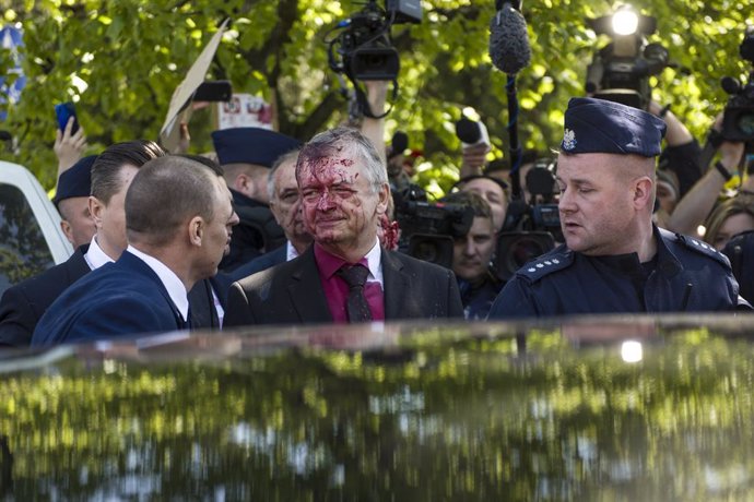 09 May 2022, Poland, Warsaw: Russia's ambassador to Poland, Sergey Andreev covered in red paint leaves the Soviet soldiers' cemetery following a ceremony on the day of the 77th anniversary of the 1945 Soviet victory against Nazi Germany. Andreev was hit