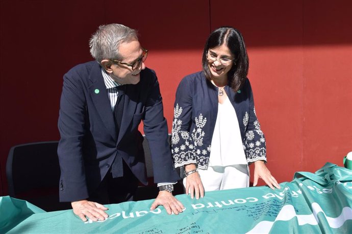 El presidente de la Asociación Española Contra el Cáncer (AECC), Ramón Reyes, y la ministra de Sanidad, Carolina Darias, en la mesa de cuestación de la AECC instalada en la explanada de entrada del Ministerio de Sanidad.