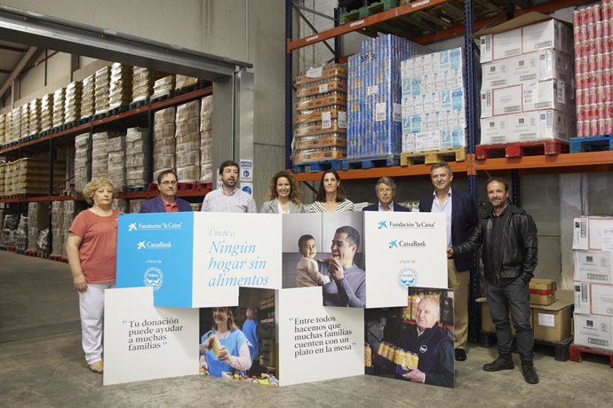 La responsable de Acción Social de CaixaBank en Andalucía Occidental y Extremadura, María del Carmen Martín, (4d) posa junto al vicepresidente Banco Alimentos de Sevilla, Francisco Arteaga, (2d) la delegada de la Fundación "la Caixa" en Andalucía, Yolan