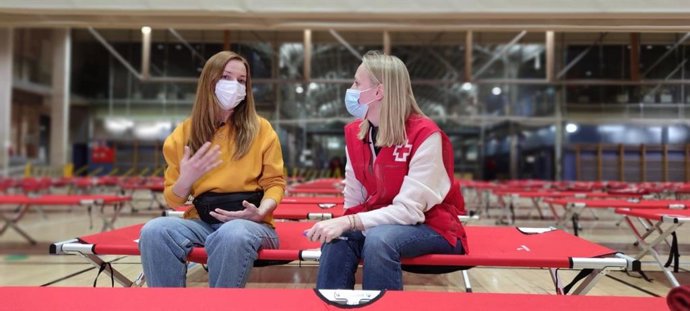 Voluntaria de Cruz Roja atendiendo a una refugiada ucraniana