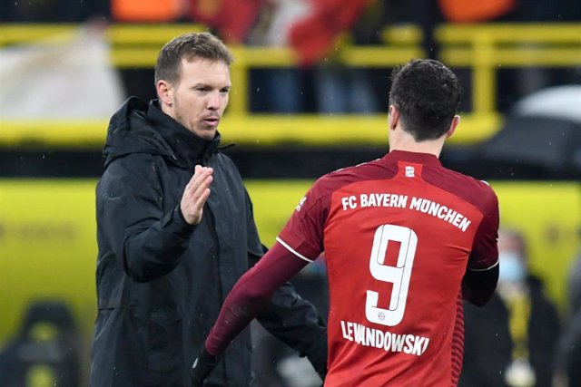 Archivo - El entrenador del Bayern de Múnich, Julian Nagelsmann (L) sauda al delantero del club bávaro Robert Lewandowski después del duelo ante el Borussia Dortmund en el Signal Iduna Park de la Bundesliga 2021-2022.