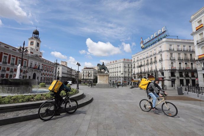 Archivo - Dos repartidores de la empresa Glovo en la Puerta del Sol 