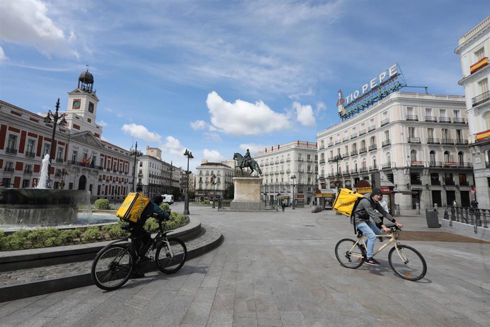 Archivo - Dos repartidores de la empresa Glovo en la Puerta del Sol