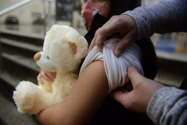 Archivo - Una niña se prepara para ser vacunada en Galicia.