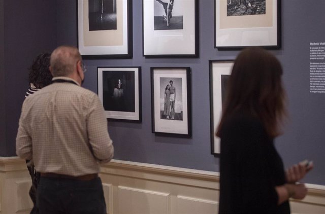 Archivo - Tres personas miran detalladamente algunas de las fotografías que componen una exposición  en el Museo del Romanticismo
