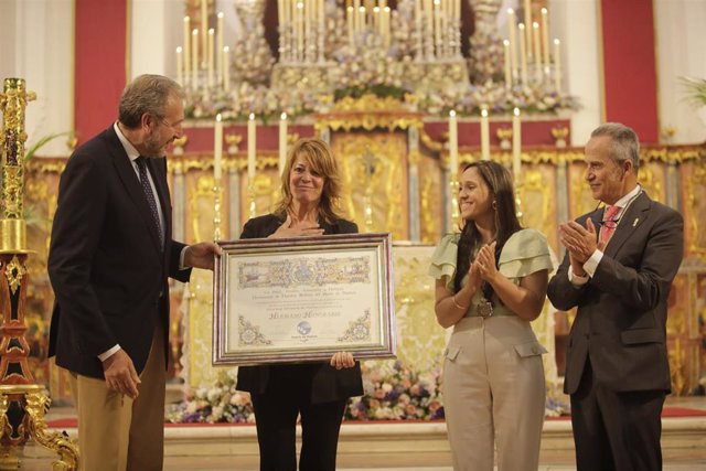 La presidenta del Puerto, Pilar Miranda, recoge el pergamino con el reconocimiento.