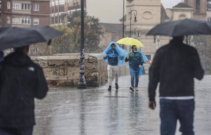 Dos personas con paraguas y chubasqueros caminan bajo la lluvia, a 3 de mayo de 2022, en Valencia, Comunidad Valenciana (España). 