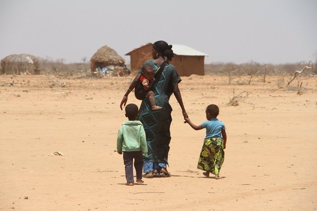 Mujer caminando con sus hijos en la aldea de Bandarero, condado de Moyale, Kenia