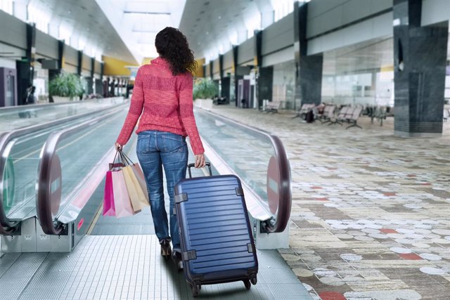 Archivo - Viajera con maleta en un aeropuerto