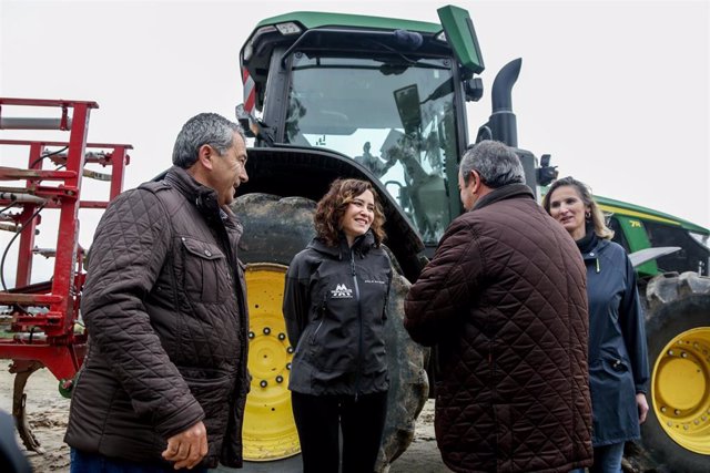 Archivo - La presidenta de la Comunidad de Madrid, Isabel Díaz Ayuso, conversa con los dueños de la explotación Agropecuaria El Espino   