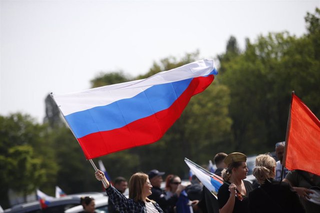 Un participante ondea la bandera rusa durante una caravana prorrusa en Colonia.