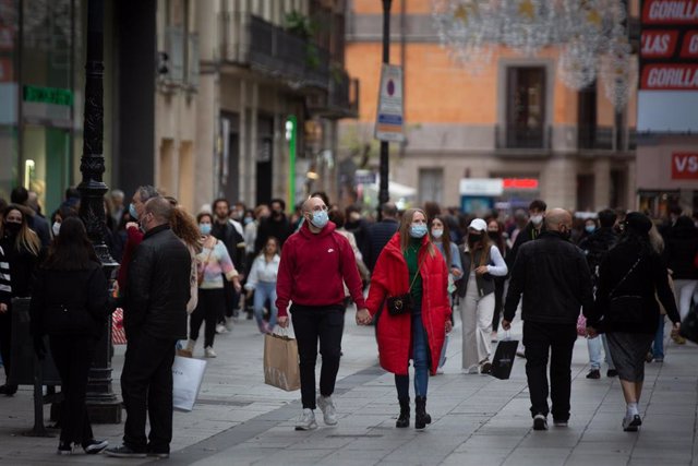 Archivo - Viandantes caminan con bolsas por una vía de Barcelona, a 27 de diciembre de 2021, en Barcelona, Catalunya, (España). - Archivo
