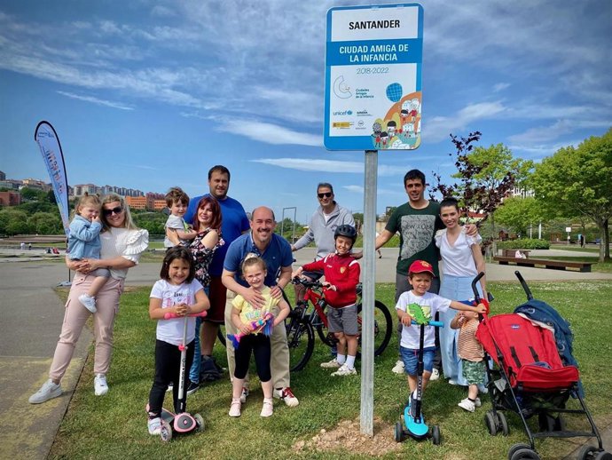 Familias junto a la placa que acredita a Santander como 'Ciudad Amiga de la Infancia'