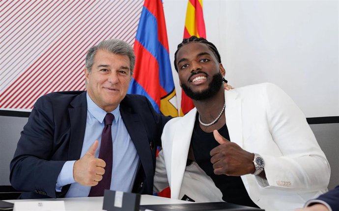 El presidente del FC Barcelona, Joan Laporta, y el jugador del Bara de balonmano Dika Mem, en la renovación del francés