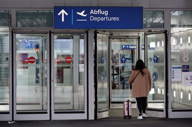 Archivo - Una mujer entra en la terminal de salidas del aeropuerto de Dusseldorf, en Alemania