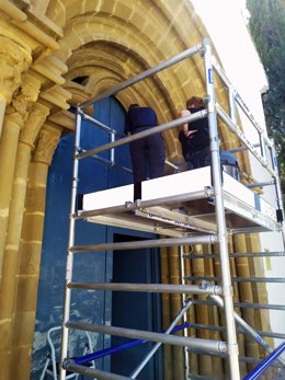 Las restauradoras del Museo Diocesano limpian la portada de la capilla del Cementerio de Barbastro.