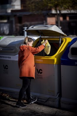 Archivo - Una ciudadana deposita una bolsa en el contenedor amarillo