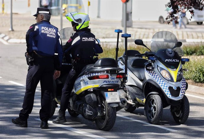 Dos agentes vigilan en el dispositivo de seguridad para las Fiestas de San Isidro en Madrid, en el Paseo de la Ermita del Santo junto al Parque de San Isidro, a 13 de mayo de 2022, en Madrid (España). 