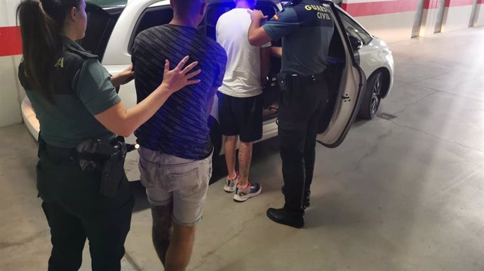 Agentes de la Guardia Civil introducen en el vehículo a los dos detenidos.