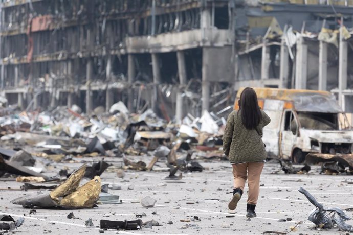 Archivo - Una mujer fotografía los destrozos en la capital de Ucrania, Kiev, tras bombardeos rusos