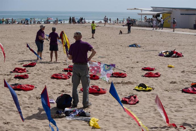 Archivo - Varias personas participan en un festival de cometas en la playa de Gandia
