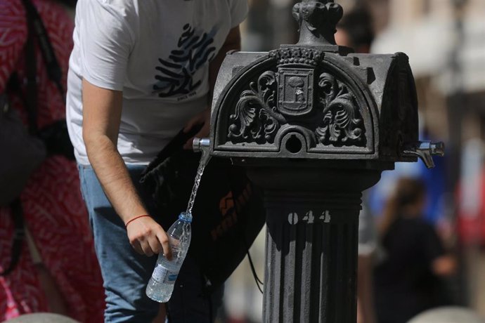 Una persona coge agua de una fuente el día en que España ha comenzado a sufrir un "importante" episodio cálido con temperaturas de pleno verano, a 17 de mayo de 2022, en Madrid (España). Algunas zonas de la península rozarán los 40 grados centígrados y 