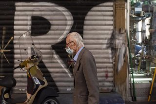 Archivo - Un ciudadano griego camina con mascarilla por las calles de la capital, Atenas