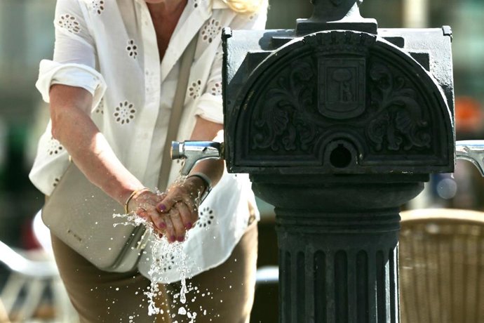 Una mujer se lava las manos en una fuente el día en que España ha comenzado a sufrir un "importante" episodio cálido con temperaturas de pleno verano, a 17 de mayo de 2022