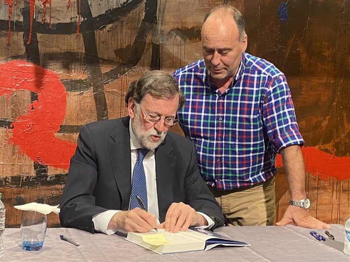 El expresidente del Gobierno de España, Mariano Rajoy, firma ejemplares de su libro 'Política para adultos', en una imagen de archivo.