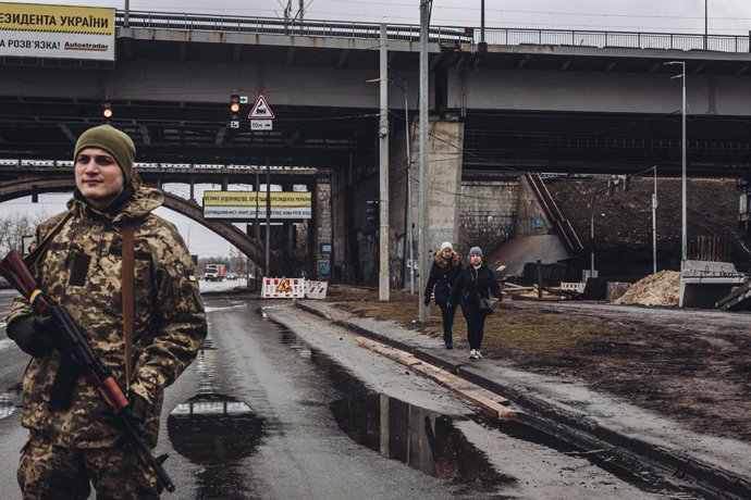Archivo - Dues dones caminen davant d'un milici ucrans a Kíiv (Ucrana)