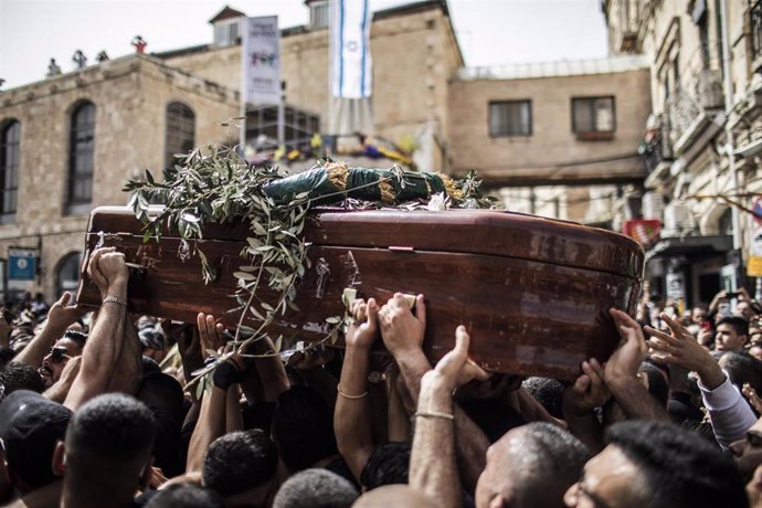 Un grupo de palestinos portan el ataúd con el cadáver de la periodista palestino-estadounidense Shirín abu Aklé, que trabajaba para Al Yazira