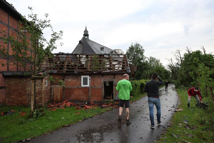 20 May 2022, North Rhine-Westphalia, Lippstadt: People stand in front of a damaged house, after a tornado caused massive damage in Lippstadt on Friday afternoon. Photo: Friso Gentsch/dpa