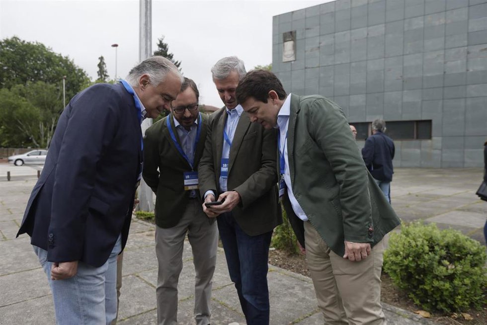 Rueda muestra su móvil a dirigentes populares.