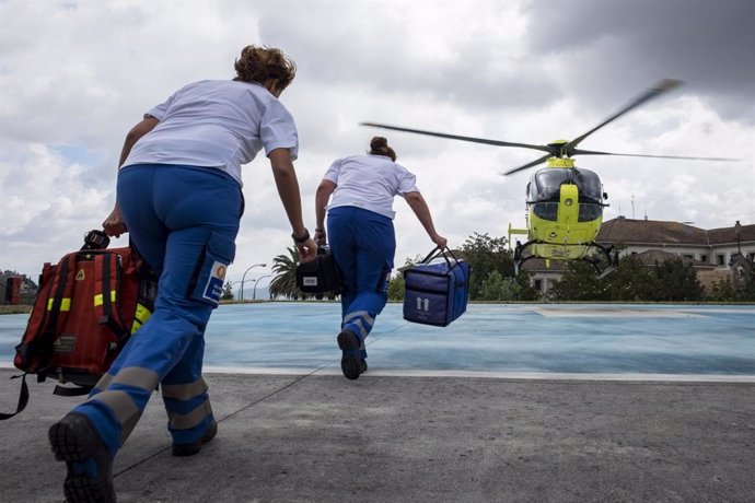 Profesionales del 061-Urxencias Sanitarias de Galicia corren hacia un helicóptero.