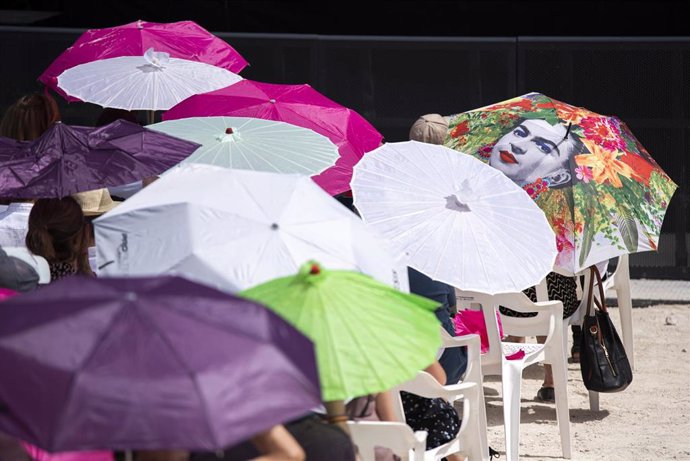 Asistentes utilizan paraguas para protegerse del sol y de la ola de calor en la Fiesta de la Primavera de Podemos, a 22 de mayo de 2022, en Valencia, Comunidad Valenciana, (España). Este evento reúne a la cúpula de la formación y sus bases y tendrá el a