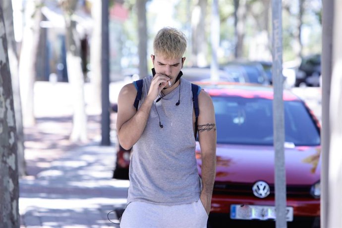 Archivo - Un joven fuma un cigarrillo