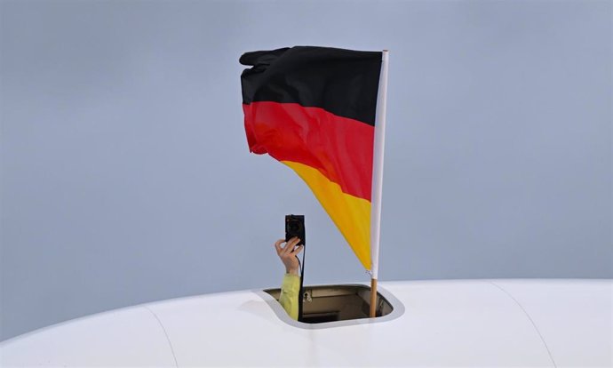 Archivo - 21 February 2022, Hessen, Frankfurt/Main: A Germany flag and a camera are held out of a hatch of the Lufthansa Boeing 747-800 as the German team returns from the Beijing 2022 Winter Olympics Games at Frankfurt Airport. Photo: Arne Dedert/dpa