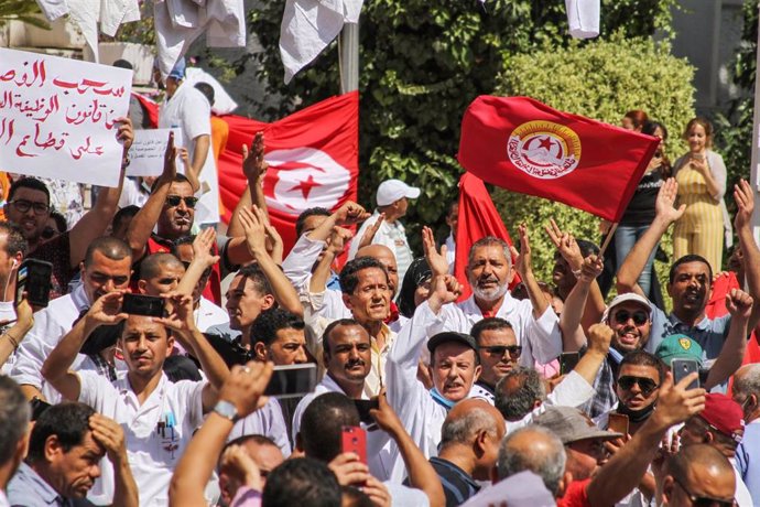 Manifestación de sanitarios con una bandera de Túnez y otra del sindicato Unión General de Trabajadores de Túnez (UGTT)