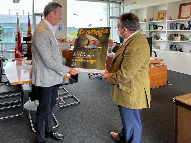 El consejero de Desarrollo Rural, Ganadería, Pesca, Alimentación y Medio Ambiente, Guillermo Blanco, presenta, junto al alcalde de Noja, Miguel Ángel Ruiz, el cartel de la Feria Internacional de Ecoturismo.
