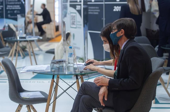 Archivo - Un hombre y una mujer trabajan en el Salón Inmobiliario de Madrid (SIMA), en Ifema.
