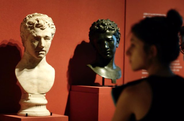 Asistente observando dos bustos de Juba II de la exposición En torno a las Columnas de Hércules. Las relaciones milenarias entre Marruecos y España, en el Museo Arqueológico Nacional (MAN)